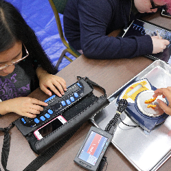 A student in NFB EQ using a Braille writer and a scale.