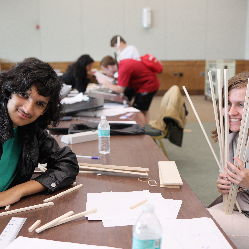 Two students in NFB EQ smiling while working with balsa wood.