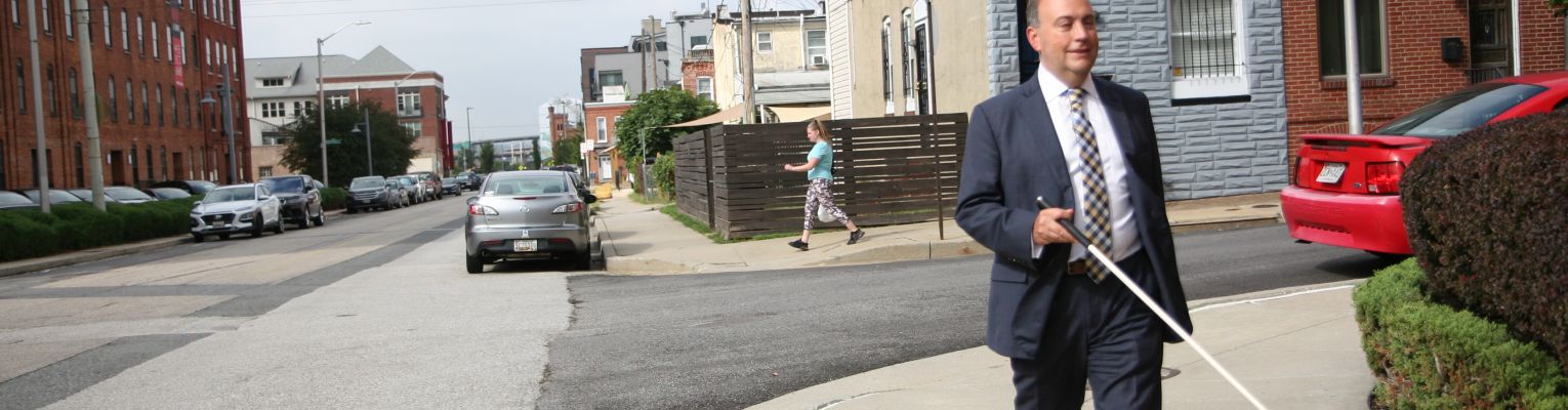 President Riccobono walks outside away from a corner of an intersection