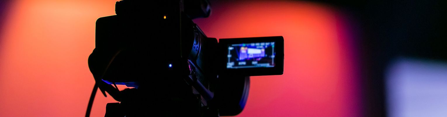 A modern video camera filming a scene.