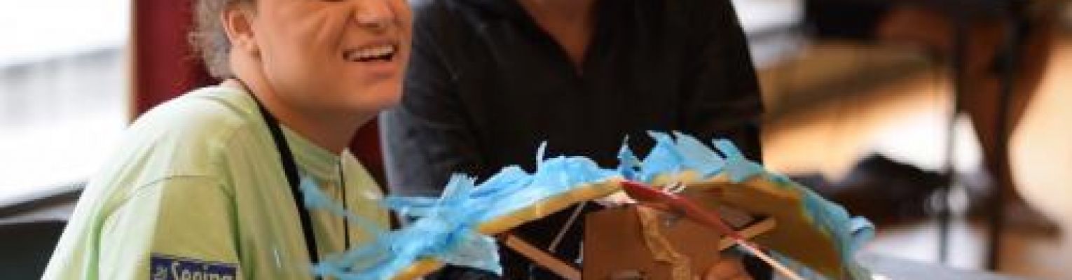 Camryn smiles while working on a motorized bird as part of the installation art project.