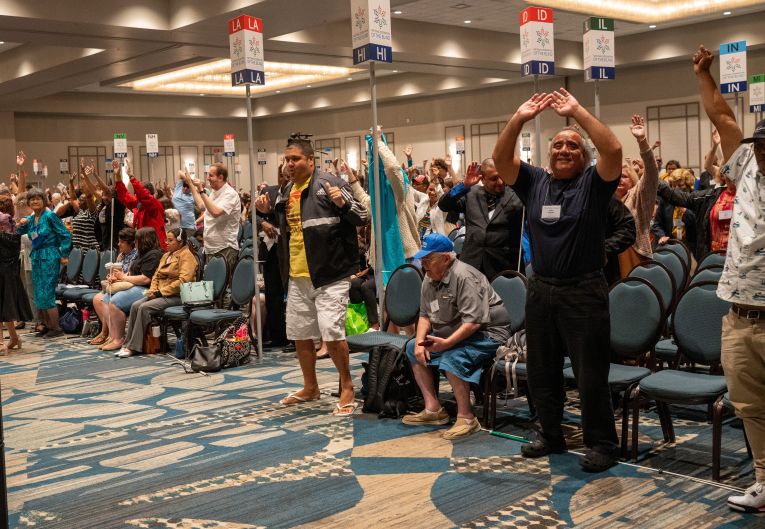 Convention attendees wave their hands and canes in the air during a fit break